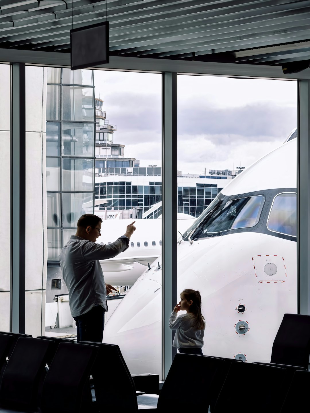空港で飛行機を見る親子。これからの旅行に使うポイントを考えるイメージ